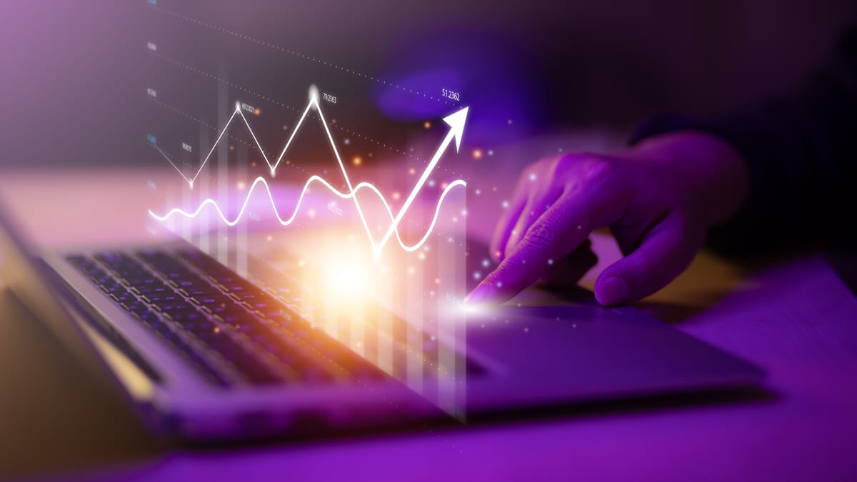 Une main sur un ordinateur portable avec un graphique de croissance digital lumineux